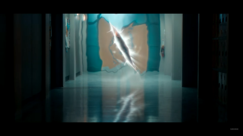 A glowing, blurred figure or light burst in a hospital-like corridor with teal and beige walls; ethereal, eerie mood.